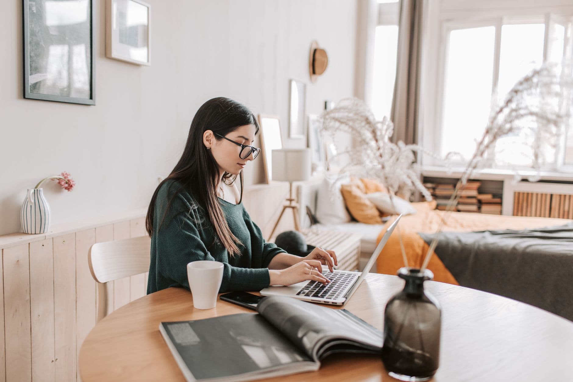 Freelance social media manager working on a laptop at a home desk