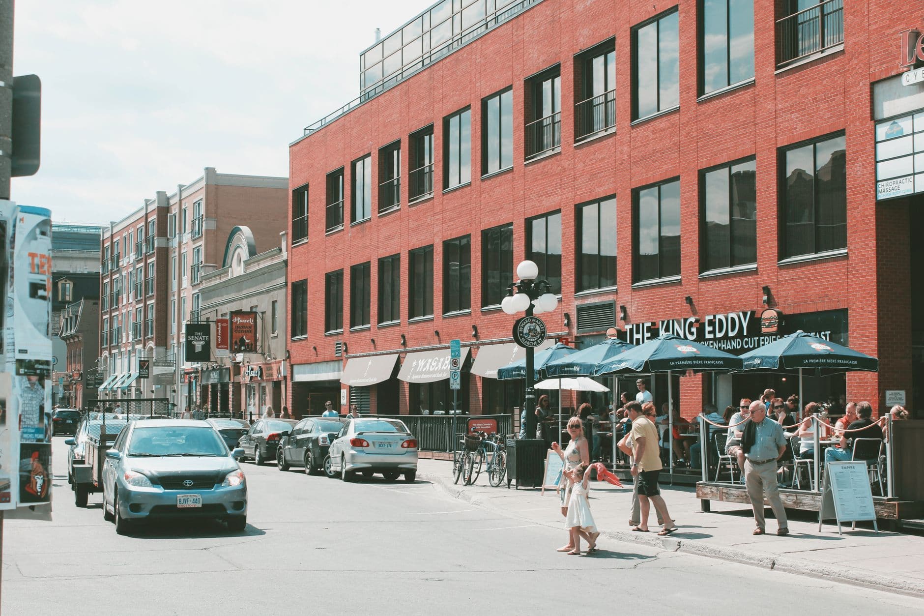 Pedestrians, patios, and storefronts on a busy downtown Ottawa street in summer