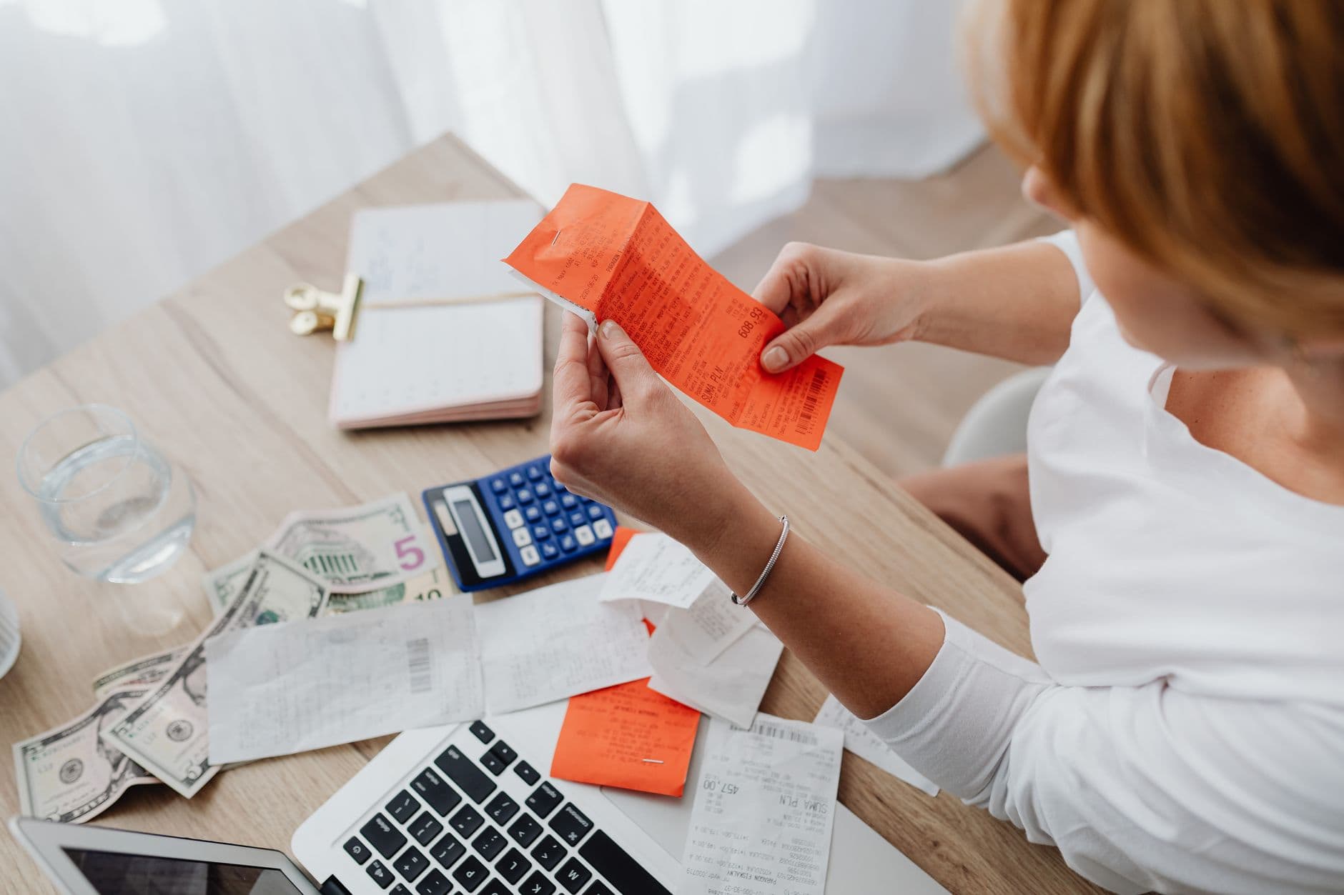 Small business owner reviewing receipts and budget numbers at a desk