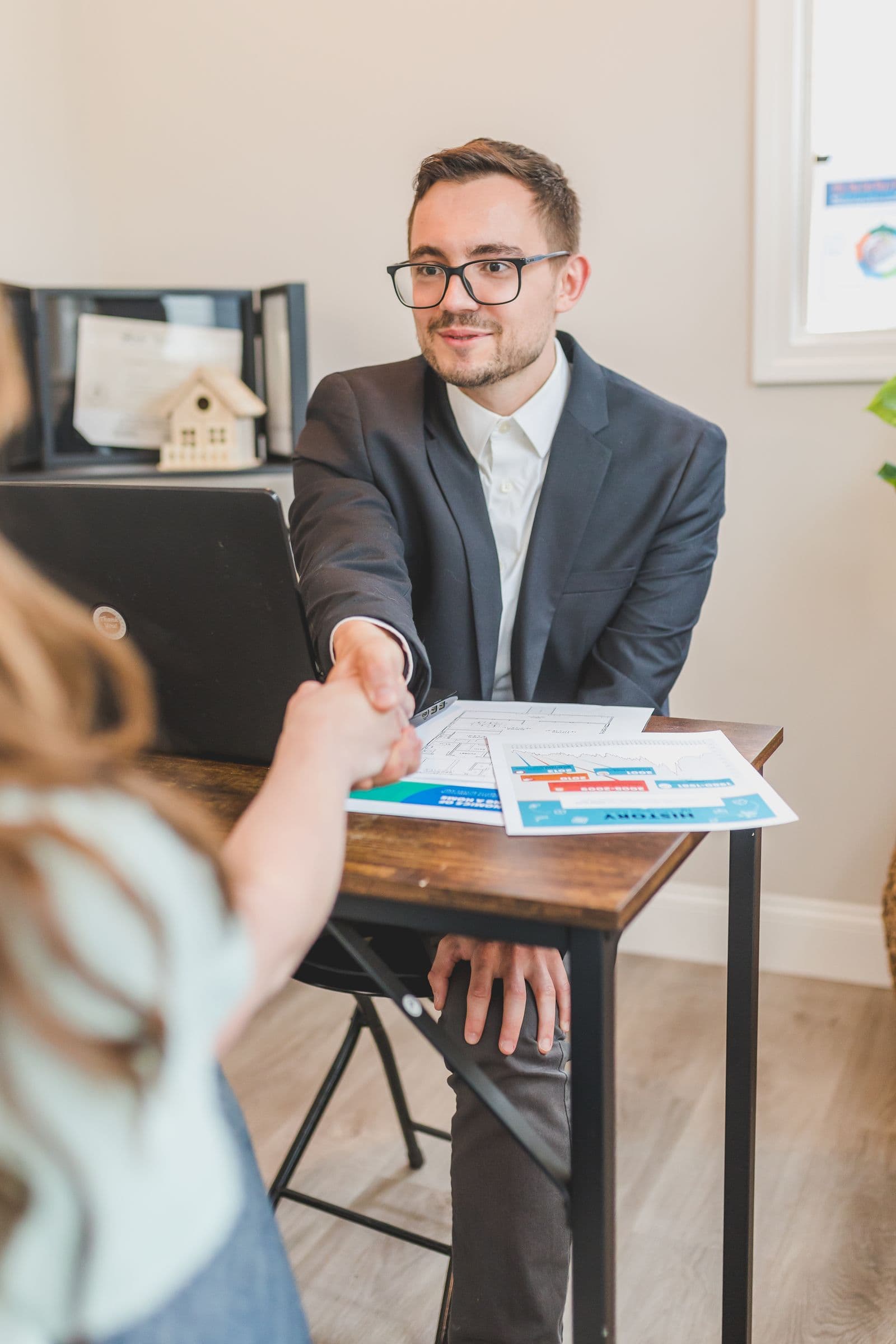 Real estate agent and client reviewing property documents at a table
