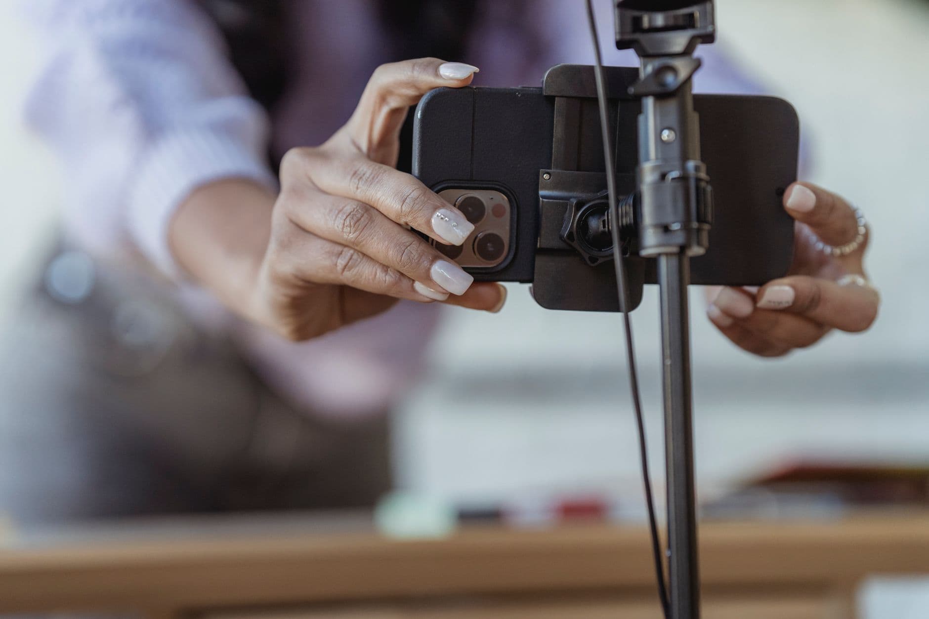 Business owner setting up a smartphone on a tripod to batch-film content