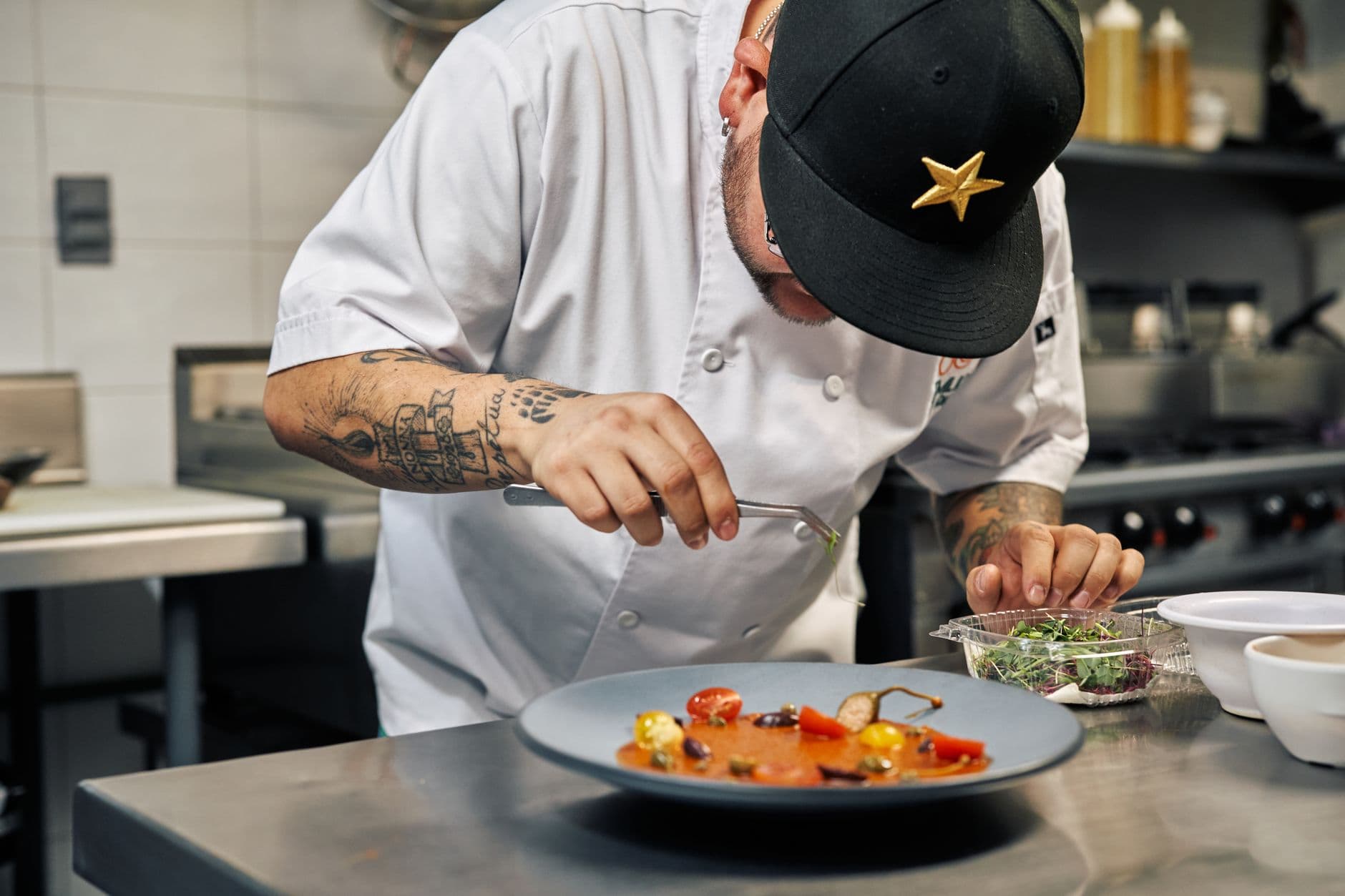 Chef adding finishing touches to a plated dish in a restaurant kitchen