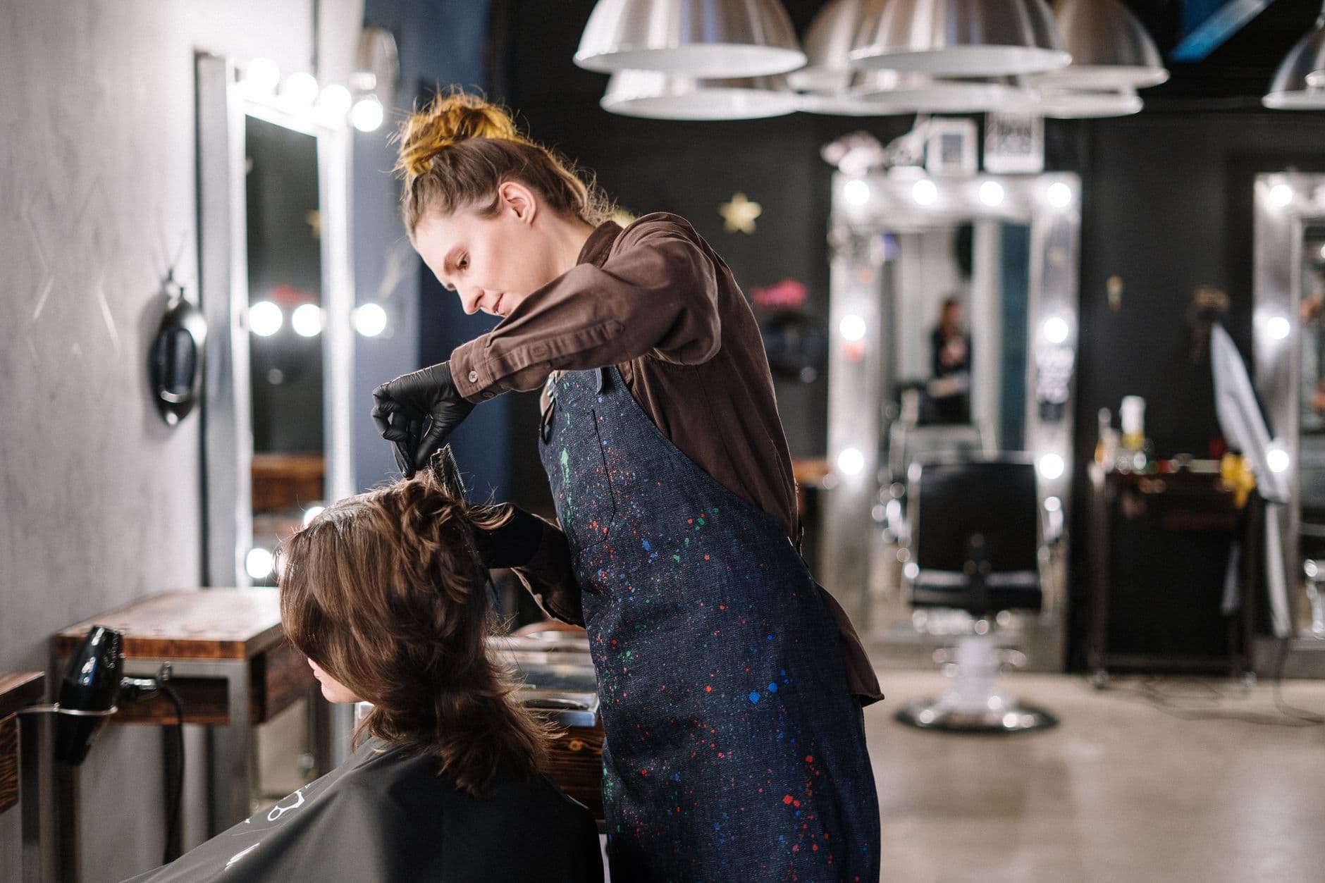 Stylist applying hair colour to a client in a modern salon